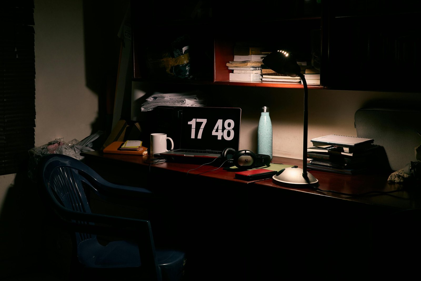 A warm and cozy home office setup featuring a desk with a laptop, lamp, and various work essentials.