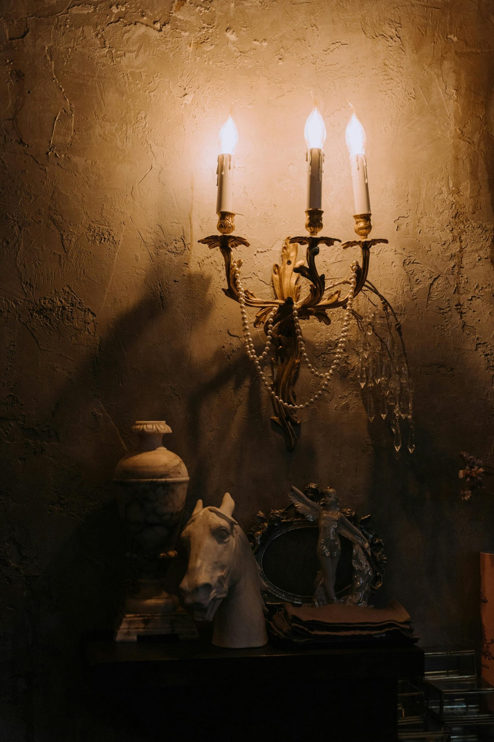 A dimly lit vintage wall sconce with candles, classic decor elements adding elegance.